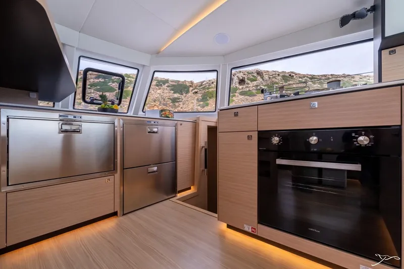 Slide: The Image of The Nautitech 44 Open 2027's kitchen features modern appliances and large windows overlooking the landscape. - 41
