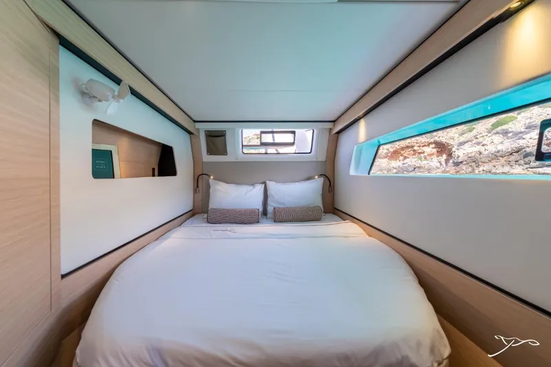 Slide: The Image of The image shows a cozy cabin with a large bed and windows offering a view of the sea. - 47