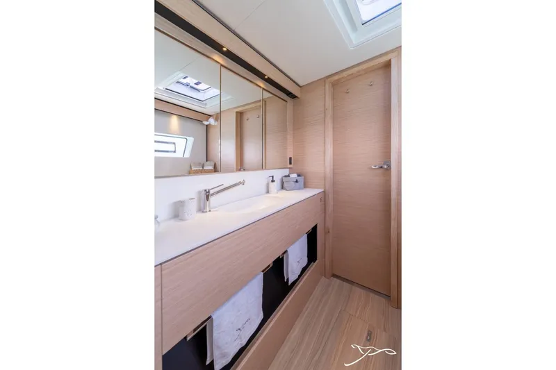 Slide: The Image of Modern bathroom with double sinks and wood paneling, well-lit by a skylight. - 34