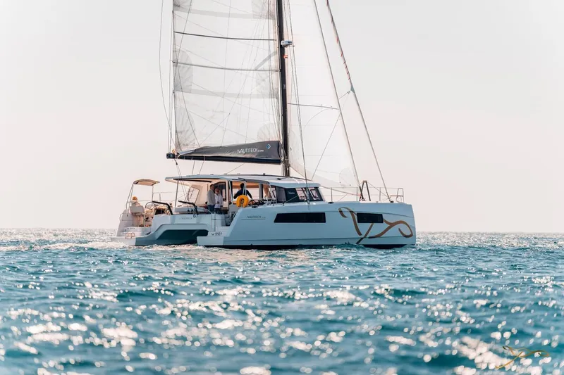 Slide: The Image of A modern catamaran sailboat, the Nautitech 44 Open, sails on calm waters under a clear sky. - 7