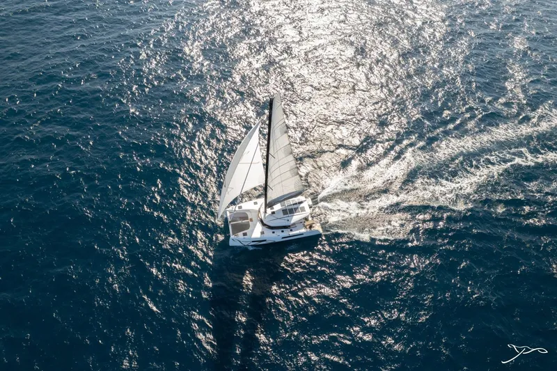 Slide: The Image of A Nautitech 44 Open catamaran sailing on open sea, with white sails and sunlight. - 9