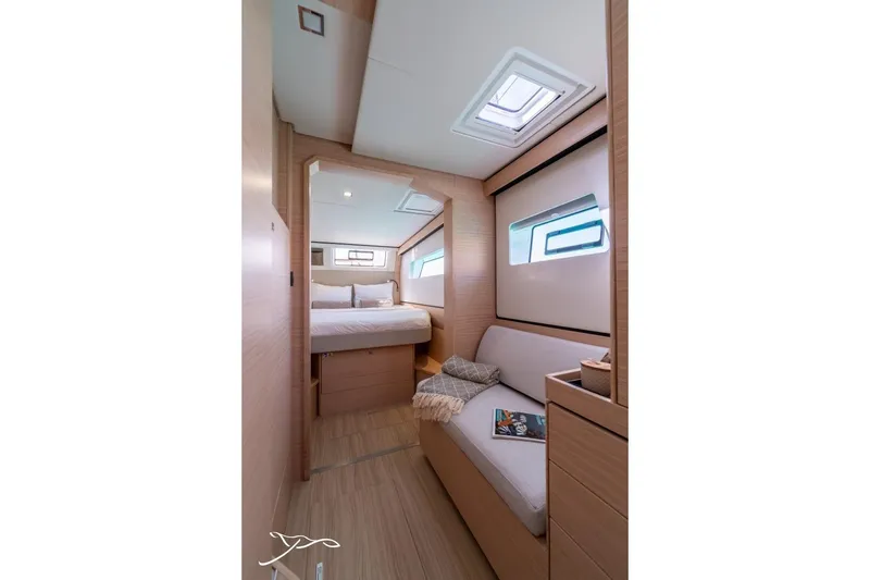 Slide: The Image of Interior of a modern yacht featuring a bed, sofa, and windows allowing natural light. - 46