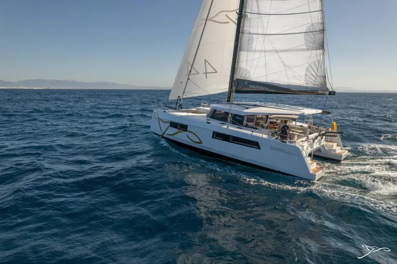The Image of A modern sailing catamaran, the Nautitech 44 Open, sails on open sea under clear skies. - 3