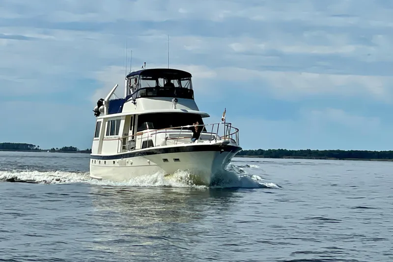 Slide: The Image of 1978 Hatteras 58 Motor Yacht cruising on calm waters under a partly cloudy sky. - 3
