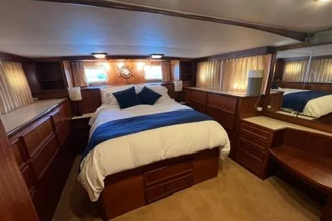 Slide: The Image of Luxurious bedroom interior of a 1978 Hatteras 58 Motor Yacht with elegant wood finishes. - 20