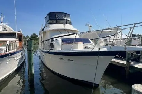 Slide: The Image of 1978 Hatteras 58 Motor Yacht docked at a marina under clear blue skies. - 44