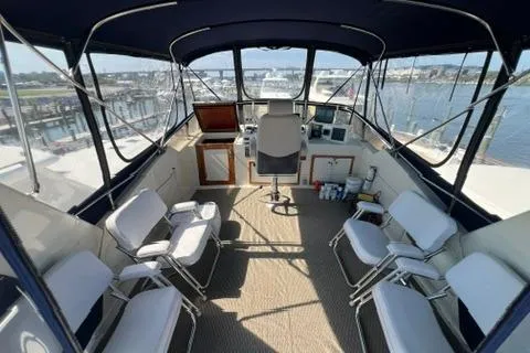 Slide: The Image of 1978 Hatteras 58 Motor Yacht helm with seating, overlooking marina. - 34