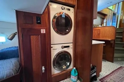 Slide: The Image of 1978 Hatteras 58 Motor Yacht interior with stacked washer and dryer in wooden cabinetry. - 15