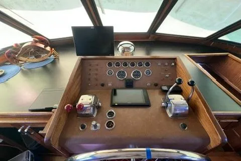 Slide: The Image of 1978 Hatteras 58 Motor Yacht helm with gauges, controls, and steering wheel. - 36