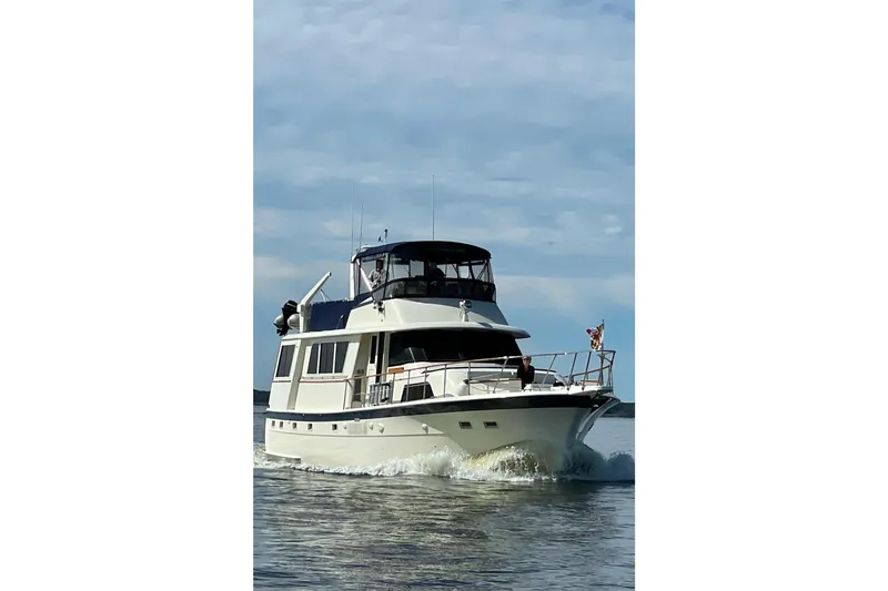 Slide: The Image of 1978 Hatteras 58 Motor Yacht cruising on open water under a clear sky. - 2