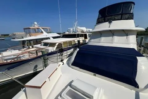 Slide: The Image of 1978 Hatteras 58 Motor Yacht docked alongside other boats under clear blue skies. - 29