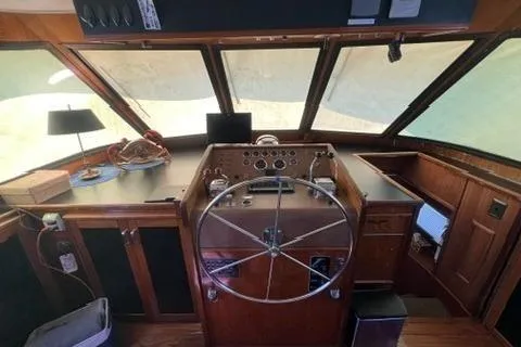Slide: The Image of The image shows the helm of a 1978 Hatteras 58 Motor Yacht with a large steering wheel and instruments. - 35