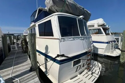Slide: The Image of 1978 Hatteras 58 Motor Yacht docked at marina under clear blue sky. - 43