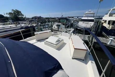 Slide: The Image of 1978 Hatteras 58 Motor Yacht docked at marina, showcasing spacious deck and sleek design. - 27
