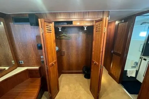 Slide: The Image of Interior of 1978 Hatteras 58 Motor Yacht with open wooden closet and seating area. - 23