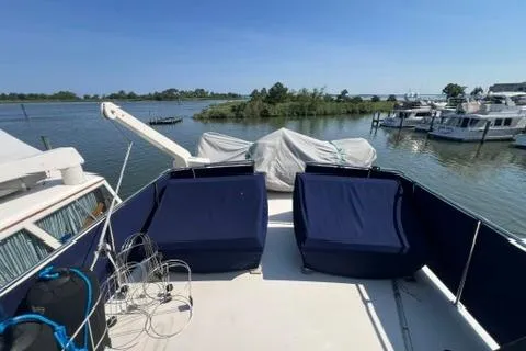 Slide: The Image of 1978 Hatteras 58 Motor Yacht deck with blue seating, overlooking marina and water. - 32