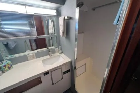 Slide: The Image of 1978 Hatteras 58 Motor Yacht bathroom with sink, mirror, and shower area. - 19
