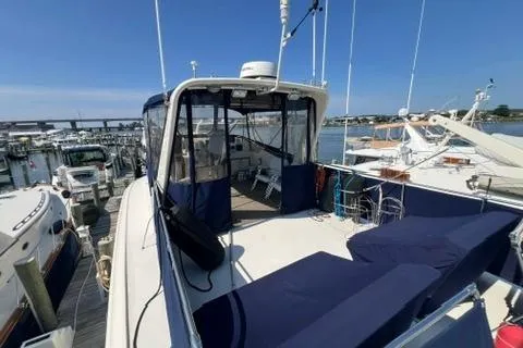 Slide: The Image of 1978 Hatteras 58 Motor Yacht docked at marina, featuring spacious deck and seating area. - 33