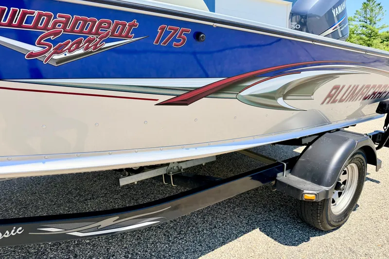 Slide: The Image of 2005 Alumacraft Tournament Sport 175 boat on trailer, featuring sleek design and vibrant graphics. - 13