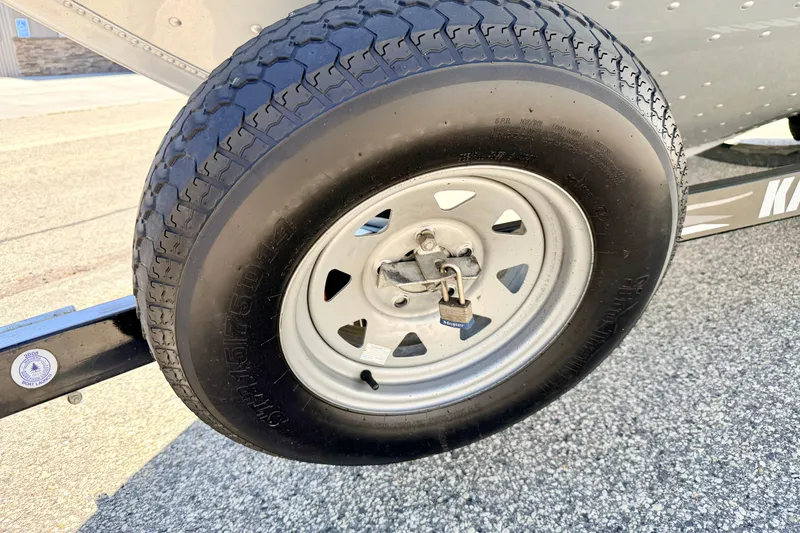 Slide: The Image of Close-up of a 2005 Alumacraft Tournament Sport 175 trailer wheel with a padlock. - 83