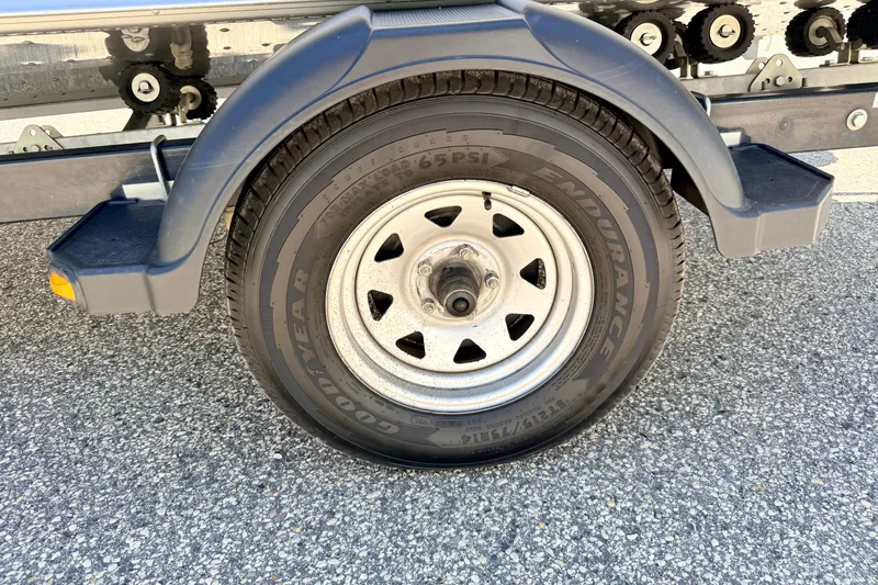 Slide: The Image of Trailer wheel of a 2005 Alumacraft Tournament Sport 175 on asphalt surface. - 84