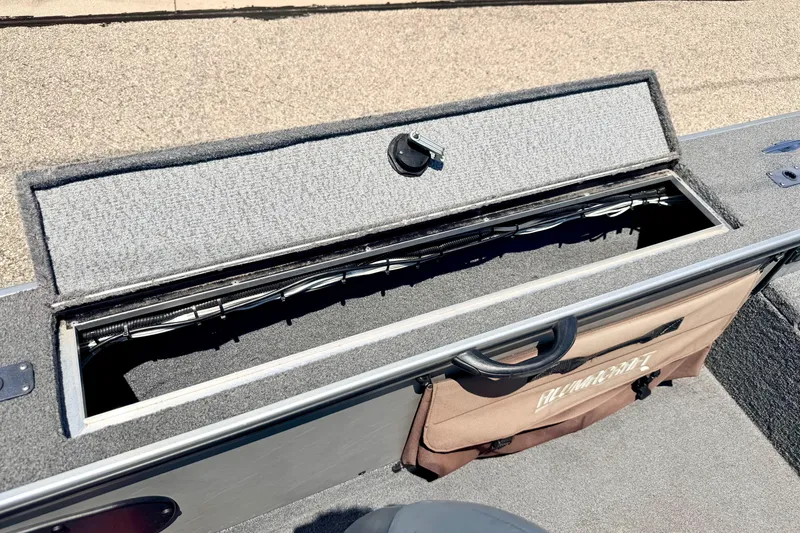 Slide: The Image of 2005 Alumacraft Tournament Sport 175 boat storage compartment with open lid and visible wiring. - 54
