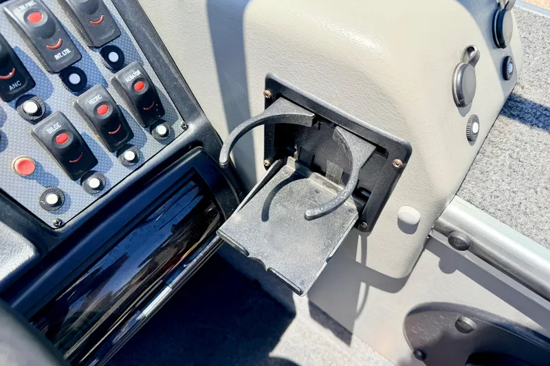Slide: The Image of Dashboard controls and cup holder in a 2005 Alumacraft Tournament Sport 175 boat. - 48