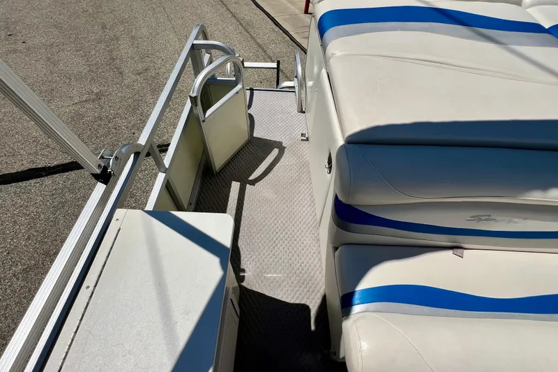 Slide: The Image of 2004 Bennington 2875RLX boat interior with white and blue seating, sunny day. - 13