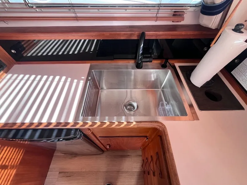Slide: The Image of The galley of a 1989 Tollycraft 30 Sport with stainless steel sink and wooden cabinets. - 17