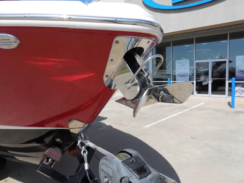 Slide: The Image of A red Chaparral 277 SSX boat with a shiny propeller, parked in front of a building. - 10