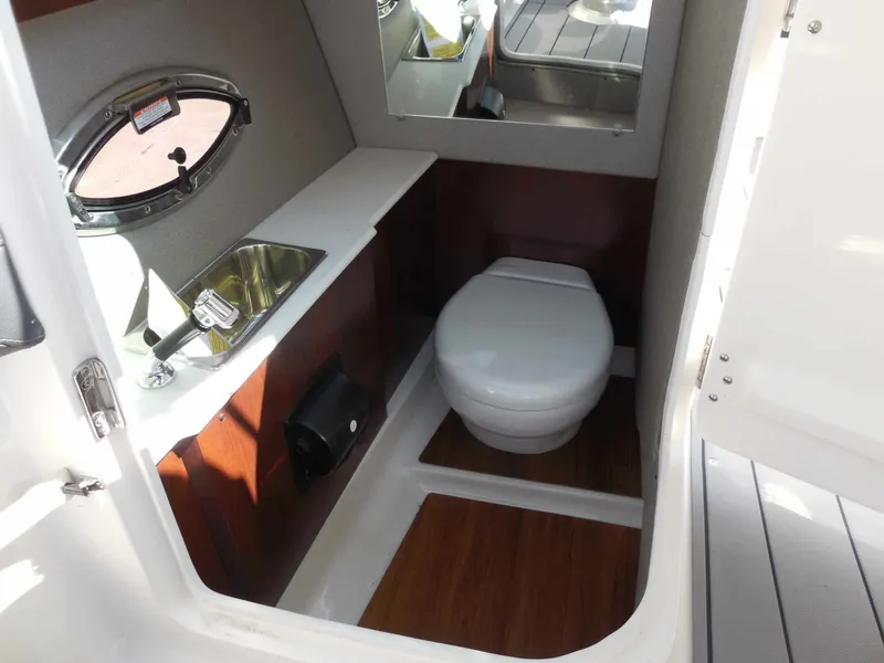 Slide: The Image of The image shows a compact boat cabin with a toilet, sink, and porthole. - 17