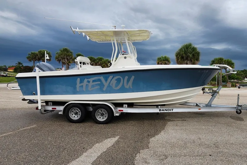 Slide: The Image of 2007 Edgewater 228CC boat on trailer, parked beside a Jeep under cloudy skies. - 8