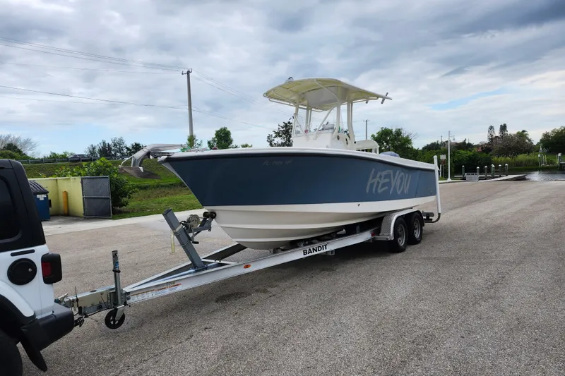 Slide: The Image of 2007 Edgewater 228CC boat on trailer, parked near a launch ramp under cloudy skies. - 2