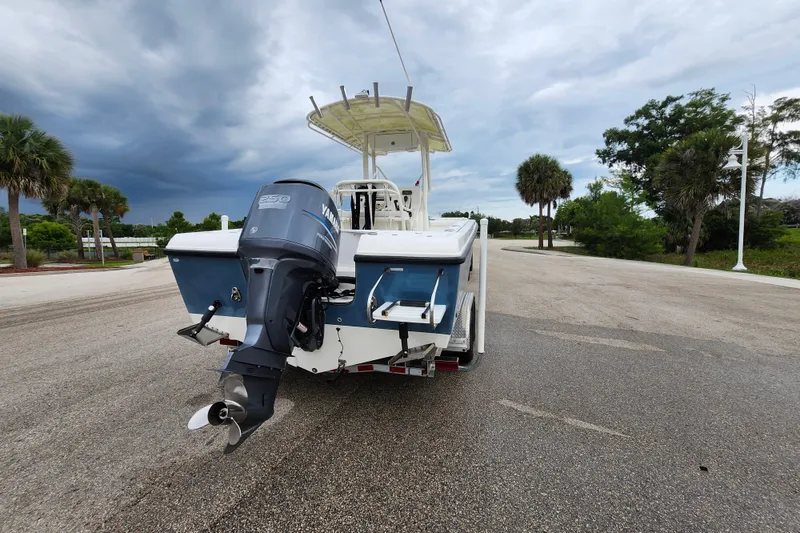 Slide: The Image of 2007 Edgewater 228CC boat with Yamaha outboard motor on a trailer, parked near palm trees. - 5