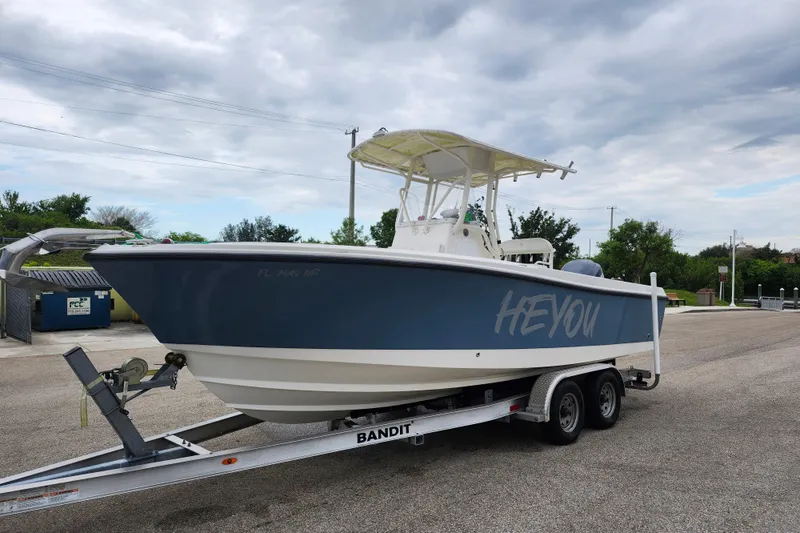 Slide: The Image of 2007 Edgewater 228CC boat on trailer, labeled "HEY YOU," under cloudy sky. - 0