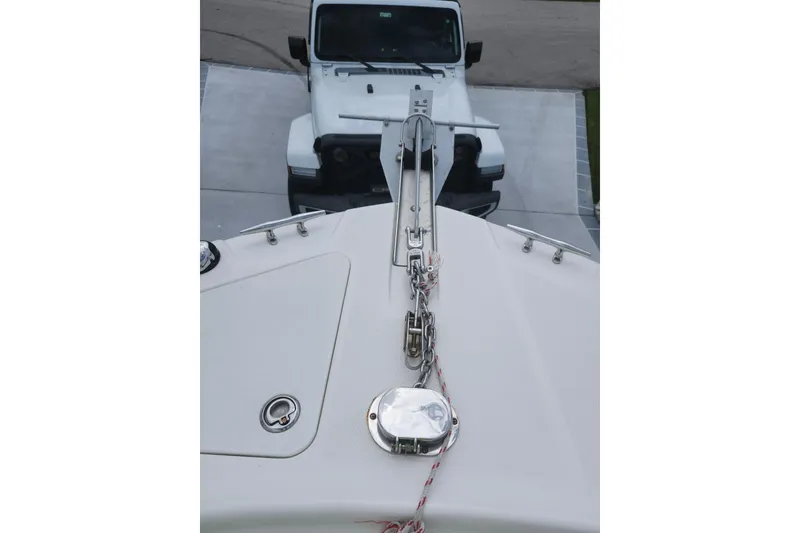 Slide: The Image of Bow of a 2007 Edgewater 228CC boat with anchor, parked near a white vehicle. - 38
