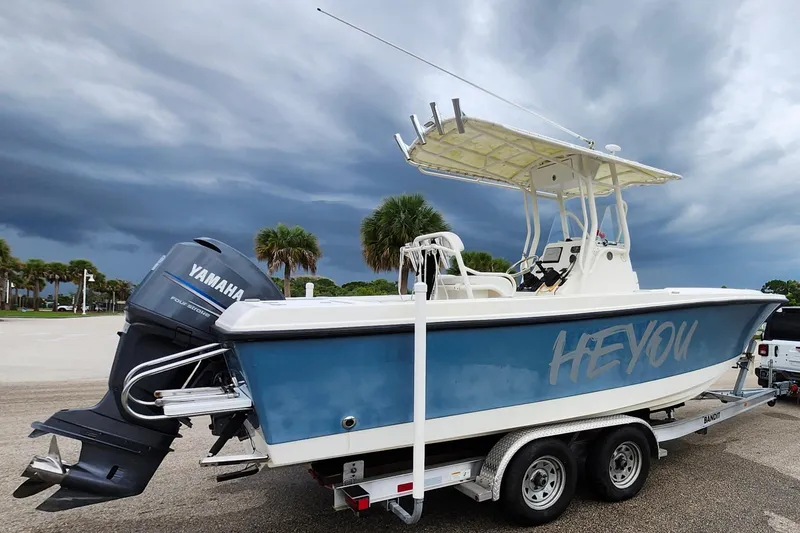 Slide: The Image of 2007 Edgewater 228CC boat on trailer, attached to a white SUV, under cloudy sky. - 7