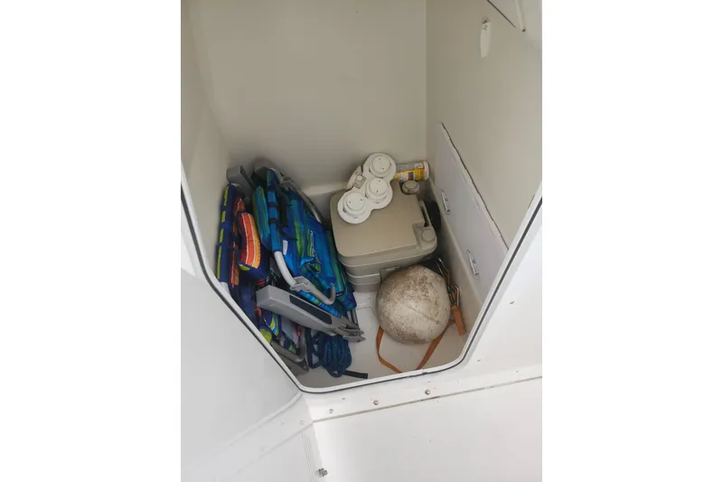 Slide: The Image of Storage compartment of a 2007 Edgewater 228CC boat with life jackets and equipment. - 27