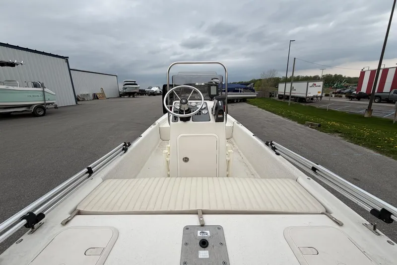 Slide: The Image of 2014 Carolina Skiff JV15CC boat interior with steering console, parked outdoors. - 13