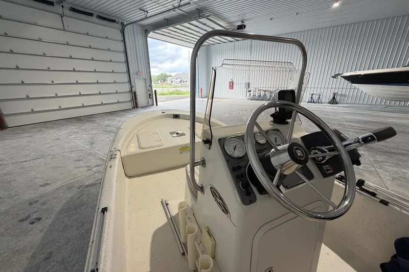 Slide: The Image of 2014 Carolina Skiff JV15CC boat interior with steering wheel in a spacious garage. - 5