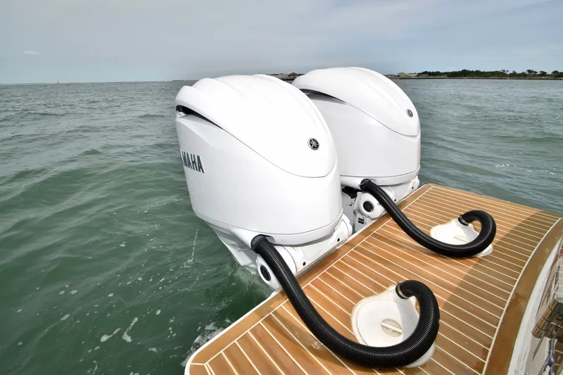 Slide: The Image of Two Yamaha outboard engines on a boat in the water, with a wooden platform in the foreground. - 49