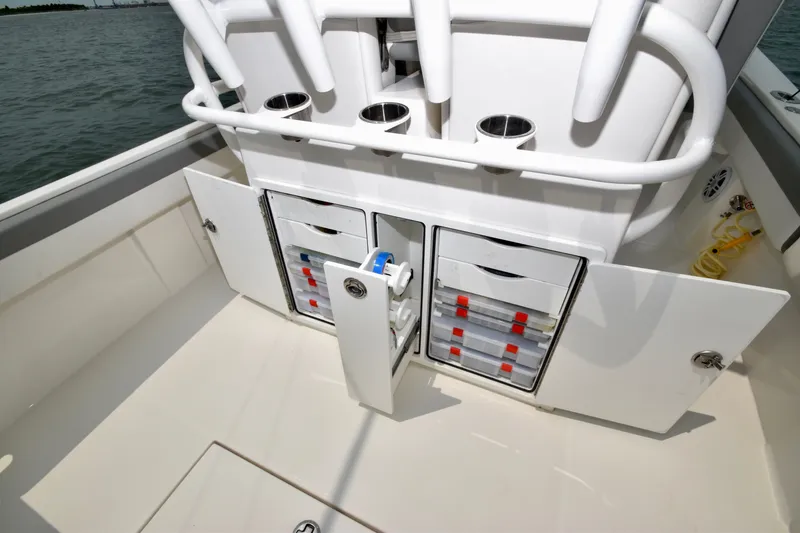 Slide: The Image of The image shows the storage area of a 2023 Regulator 28 Forward Seating boat with drawers and holders. - 39