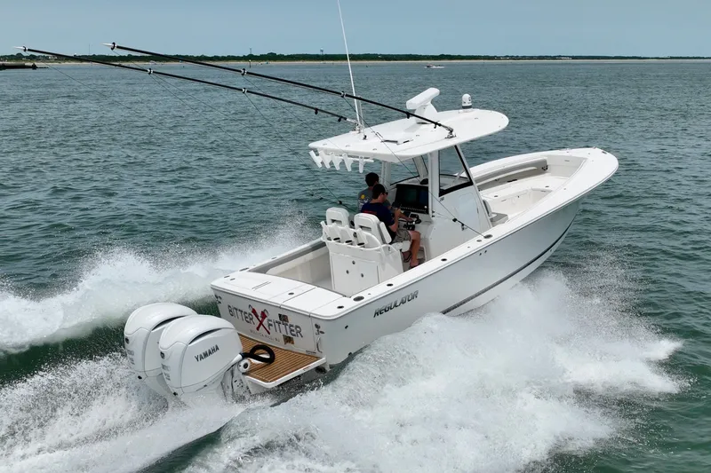 The Image of A white boat with two outboard engines speeds across the water. - 0