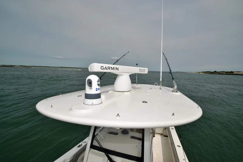 Slide: The Image of A Regulator 28 Forward Seating boat with Garmin radar on the roof, on calm waters. - 25