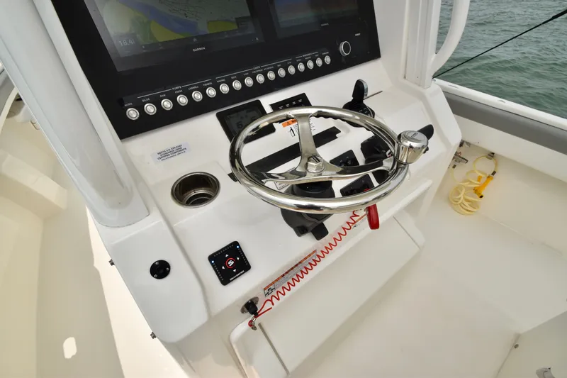 Slide: The Image of The image shows the helm of a 2023 Regulator 28 Forward Seating boat with modern instruments. - 30