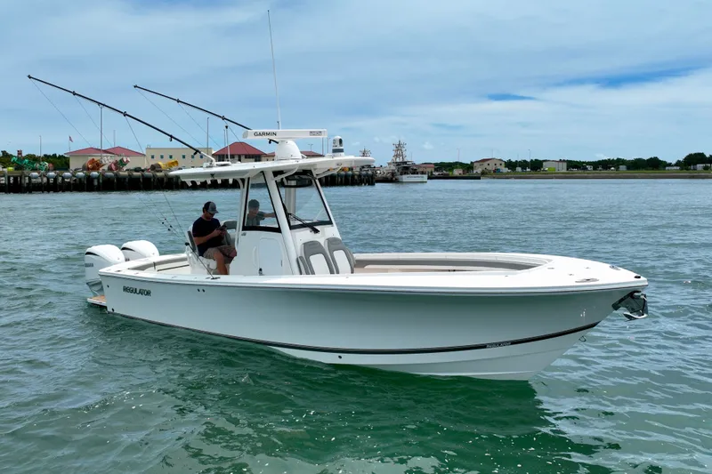 Slide: The Image of A white boat on calm water with two people aboard and fishing rods. - 2