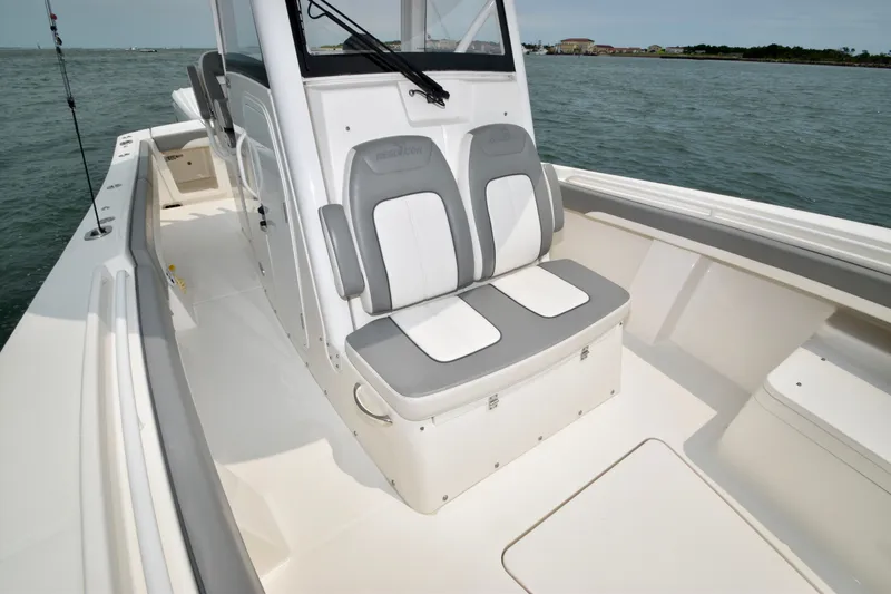 Slide: The Image of A 2023 Regulator 28 with forward seating on calm water. White upholstery with gray accents. - 22