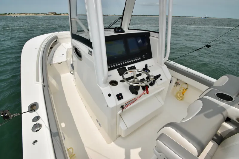 Slide: The Image of The image shows the cockpit of a 2023 Regulator 28 Forward Seating boat on the water. - 27