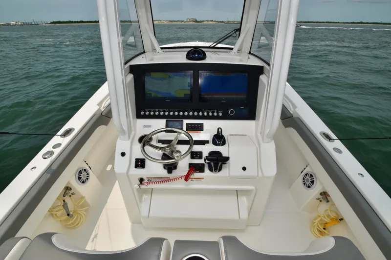 Slide: The Image of The image shows the cockpit of a 2023 Regulator 28 Forward Seating boat with modern electronics. - 28