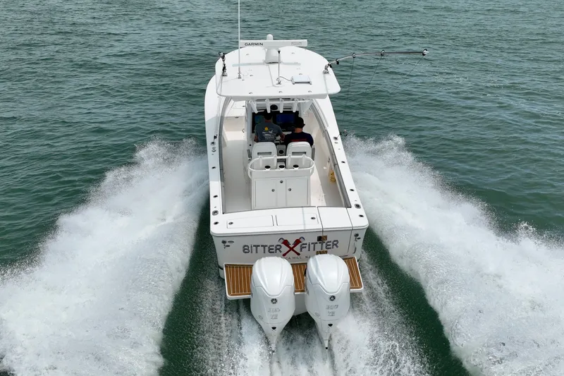 Slide: The Image of A 2023 Regulator 28 Forward Seating boat speeds across the water, featuring twin outboard engines. - 14